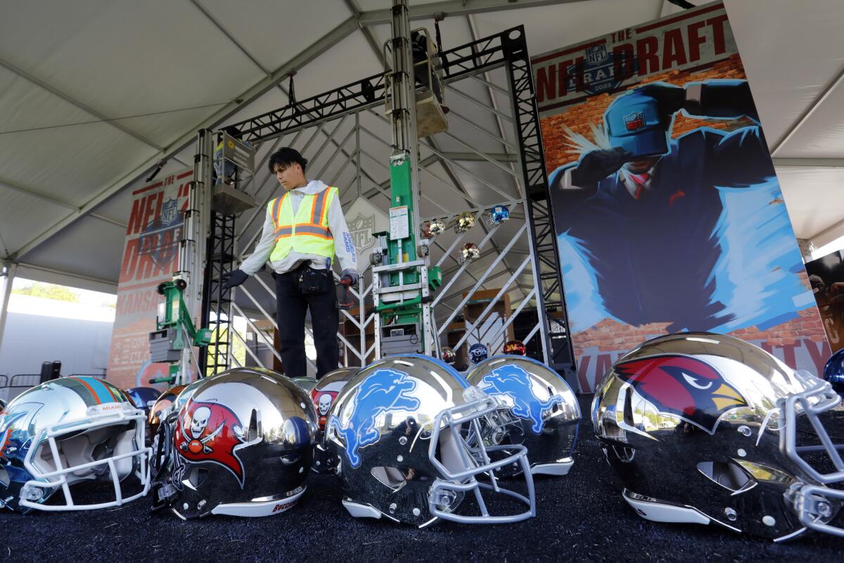 Workers install a helmet display on the south lawn of The National WWI Museum and Memorial.