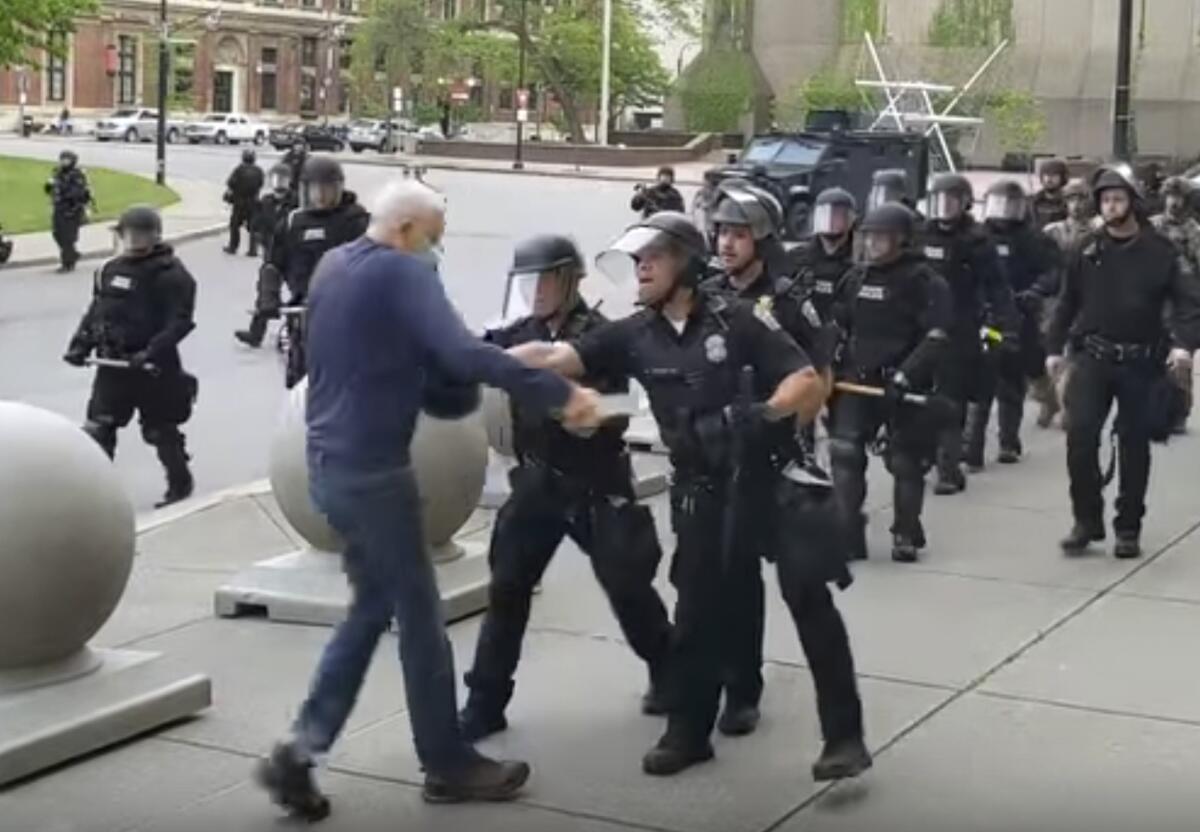 A man begins to fall after being pushed by Buffalo police