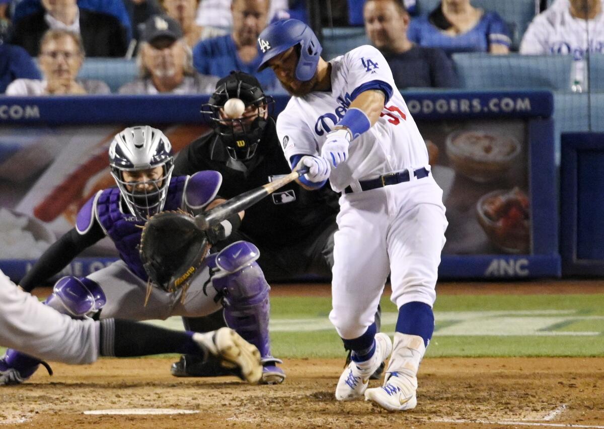 Russell Martin hits a three-run home run in front of Colorado Rockies catcher Tony Wolters during the seventh inning of the Dodgers' 5-3 victory Tuesday. 