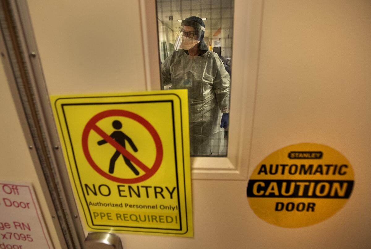 A warning sign marks the COVID-19 isolation area of the emergency department at Los Angeles County+USC Medical Center.