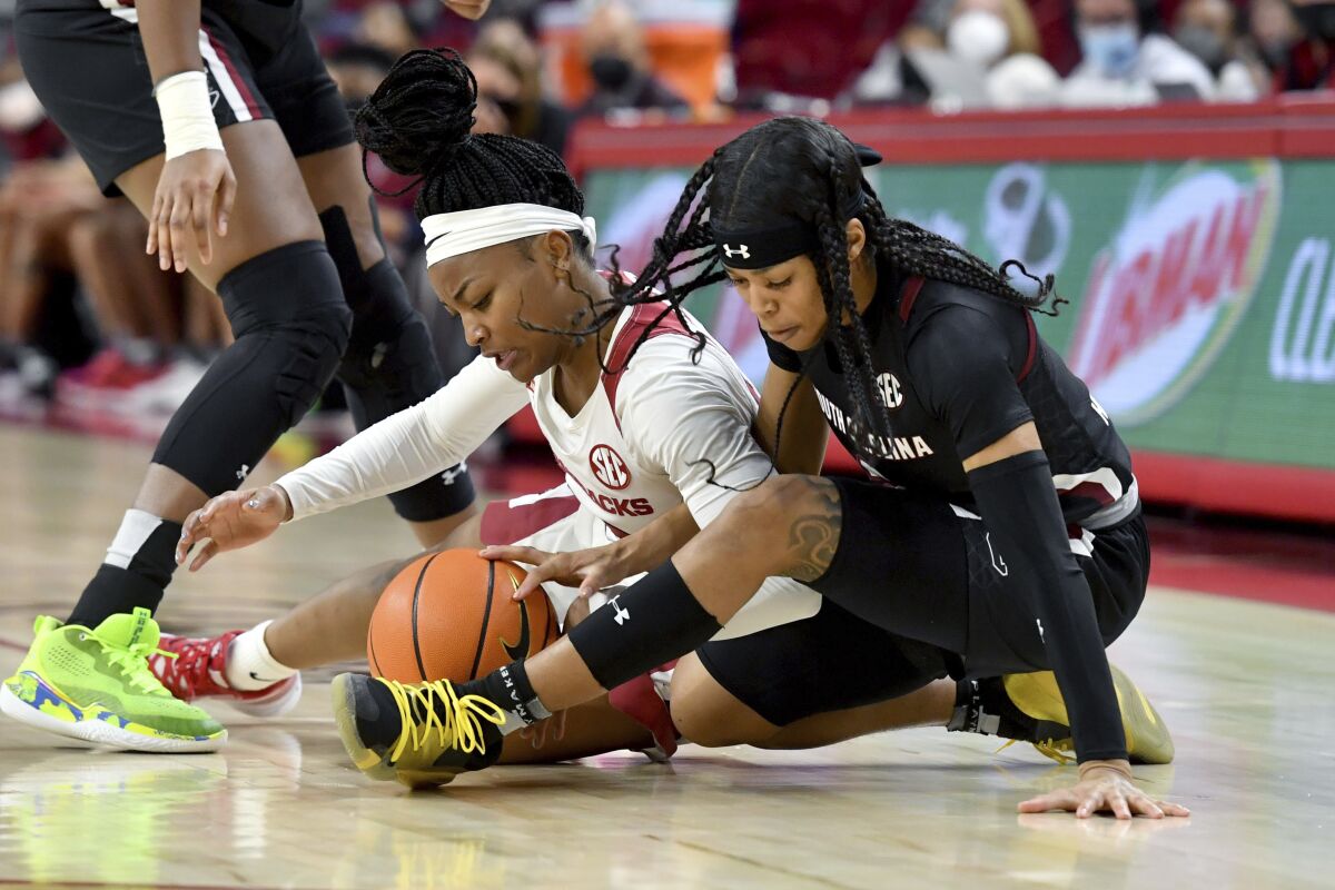 Arkansas guard Makayla Daniels (43) and South Carolina guard Destanni Henderson (3) fight for the ball during the second half of an NCAA college basketball game Sunday, Jan. 16, 2022, in Fayetteville, Ark. (AP Photo/Michael Woods)