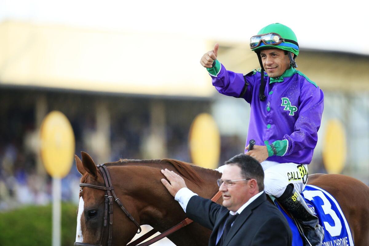 Jockey Victor Espinoza gives the thumbs-up sign as assistant trainer Alan Sherman greets California Chrome after his victory in the Preakness Stakes on Saturday at Pimlico Race Course in Baltimore.