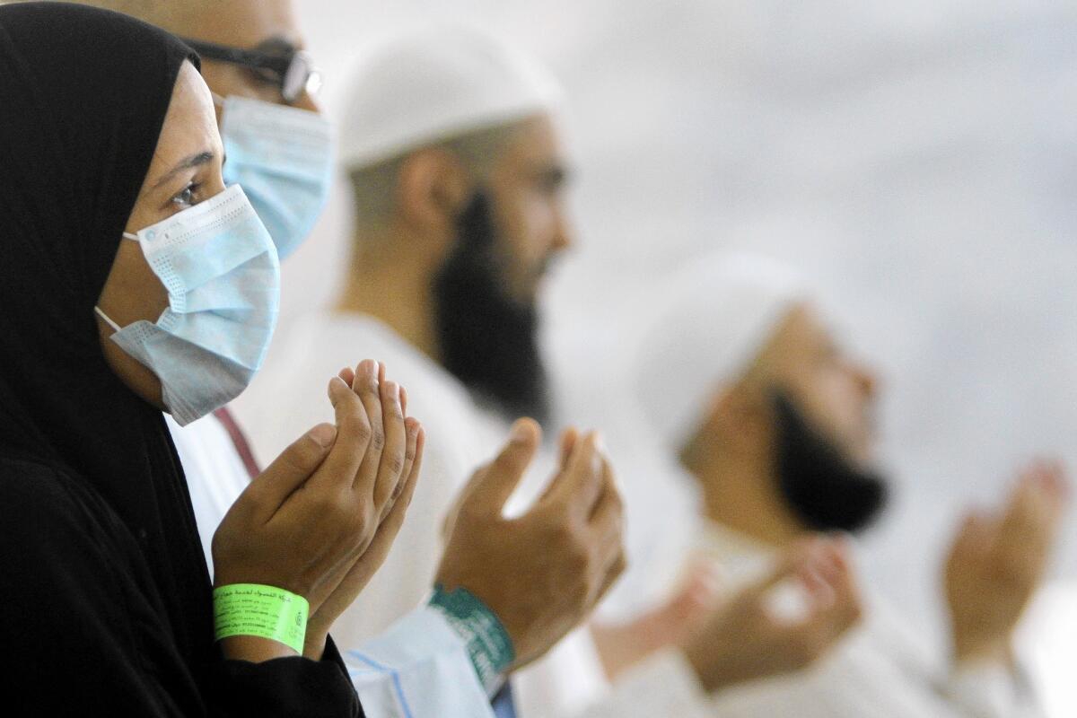 Egyptian Muslim pilgrims, some wearing masks as a precaution against Middle East Respiratory Syndrome, pray in Mina near the Muslim holy city of Mecca, Saudi Arabia, during last October's hajj.
