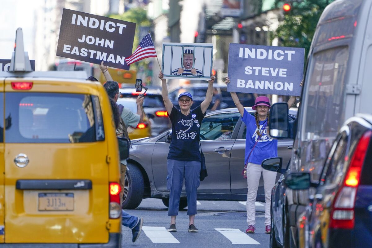 Protesters hold signs amid traffic in front of Trump Tower in New York