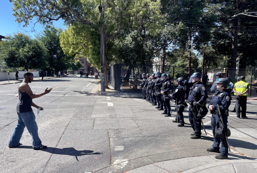 A man approaches a line of police.