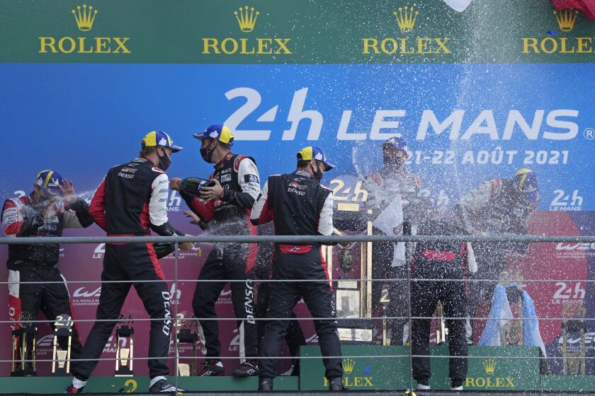 FILE - The Toyota Gazoo Racing's winner drivers Mike Conway of Britain, Kamui Kobayashi of Japan and Jose Maria Lopez of Argentina, and the second placed drivers Sebastien Buemi of Switzerland, Kazuki Nakajima of Japan and Brendon Hartley of New Zeland celebrate on the podium of the 24-hour Le Mans endurance race in Le Mans, France, on Aug. 22, 2021. The world's most famous endurance race will be open to hydrogen-powered cars starting in 2026, Pierre Fillon, the president of the Automobile Club de l'Ouest, said Saturday, May 27, 2023. (AP Photo/Francois Mori, File)