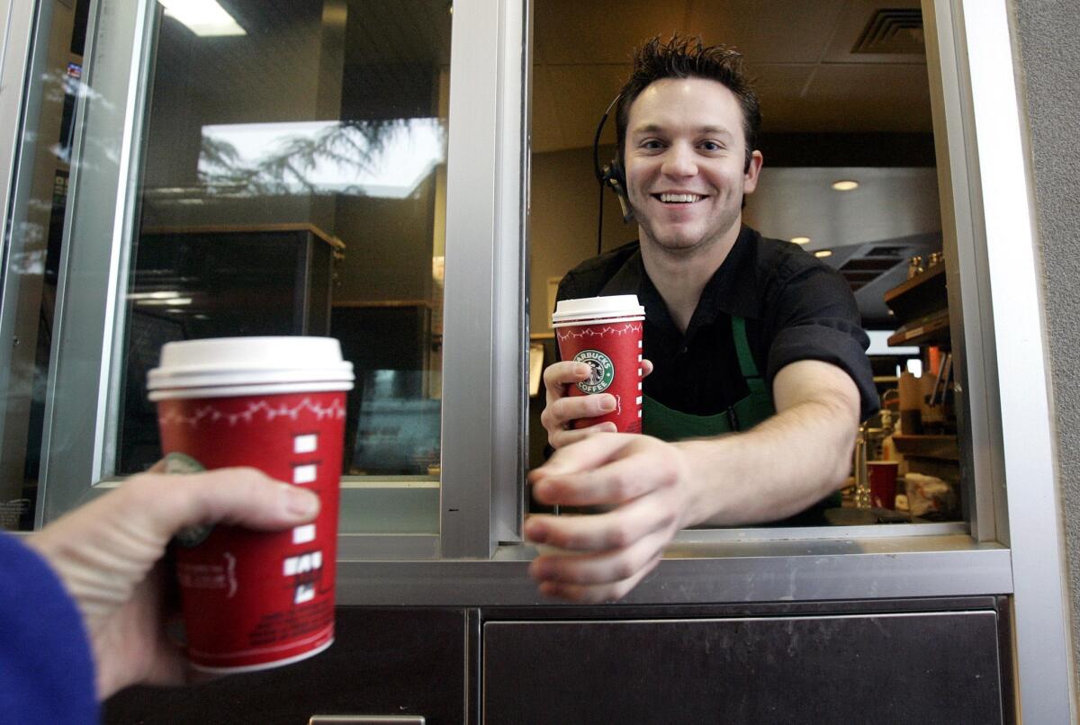 Starbucks will release its new Chestnut Praline Latte Nov. 12. Pictured is a barista in Washington delivering a drink to a customer in a holiday cup in 2005.