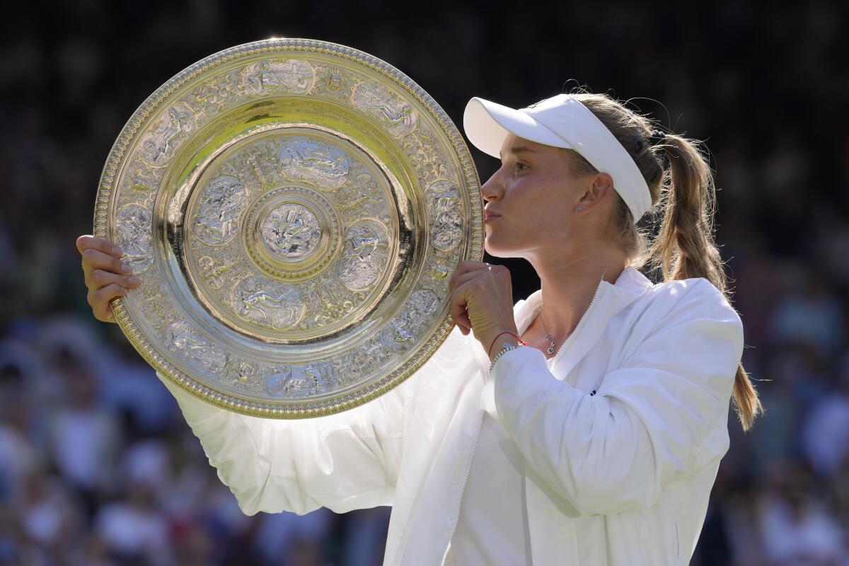 Elena Rybakina kisses the trophy as she celebrates winning the Wimbledon women's singles championship on Sunday.