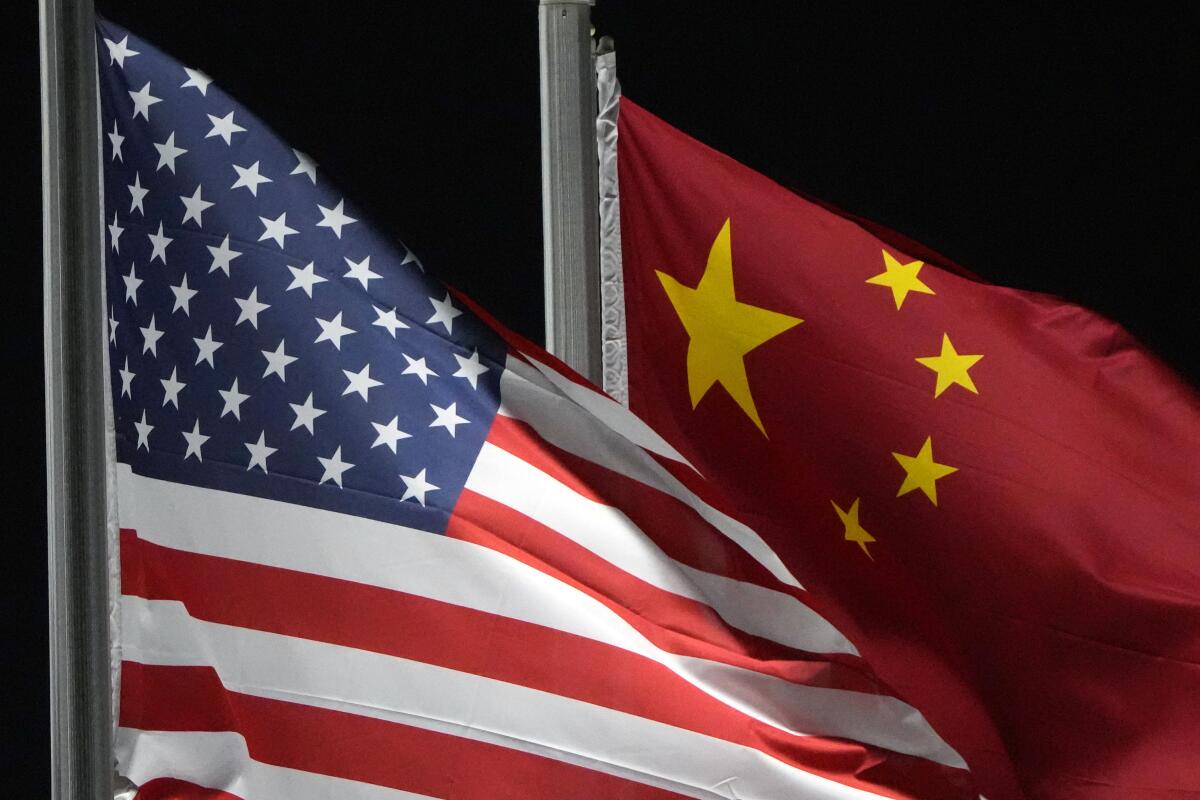 ARCHIVO - Las banderas estadounidense y china ondean una al lado de la otra en el parque Genting Snow