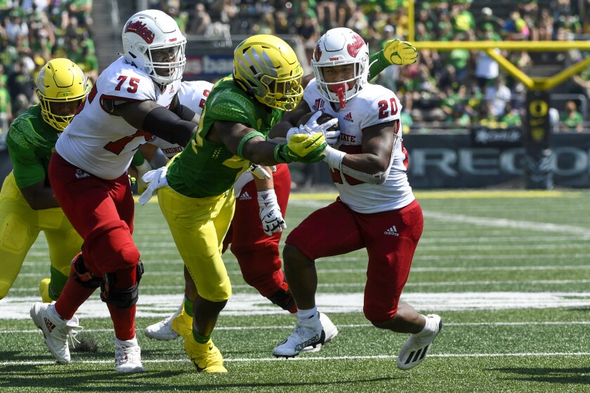 Fresno State offensive lineman Alex Akingbulu (75) blocks for running back Ronnie Rivers.