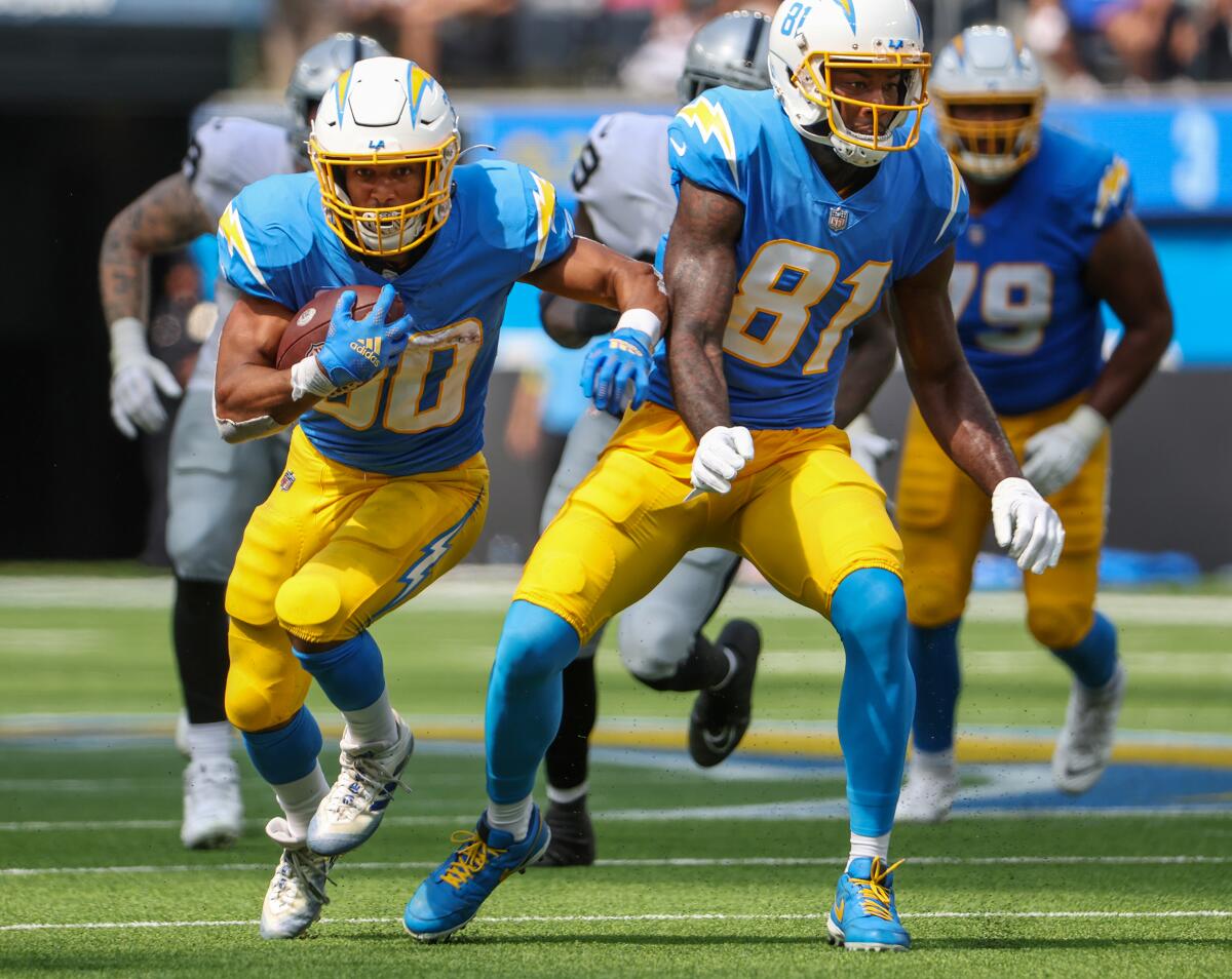 Chargers running back Austin Ekeler runs with the ball as wide receiver Mike Williams positions himself to make a block.