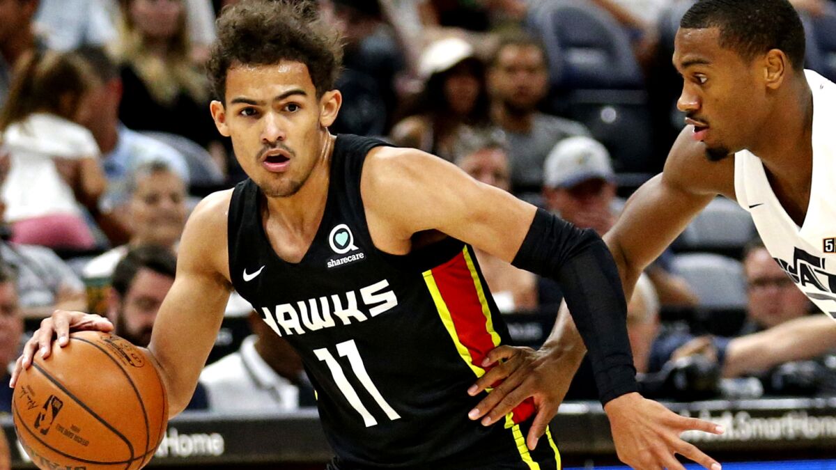 Hawks guard Trae Young, left, drives past Jazz guard Trey Lewis during a Summer League game in Salt Lake City earlier this month.