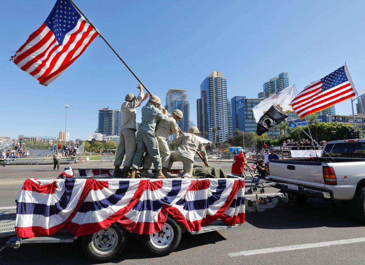 Humans on a float reenact the flag-raising on Iwo Jima 