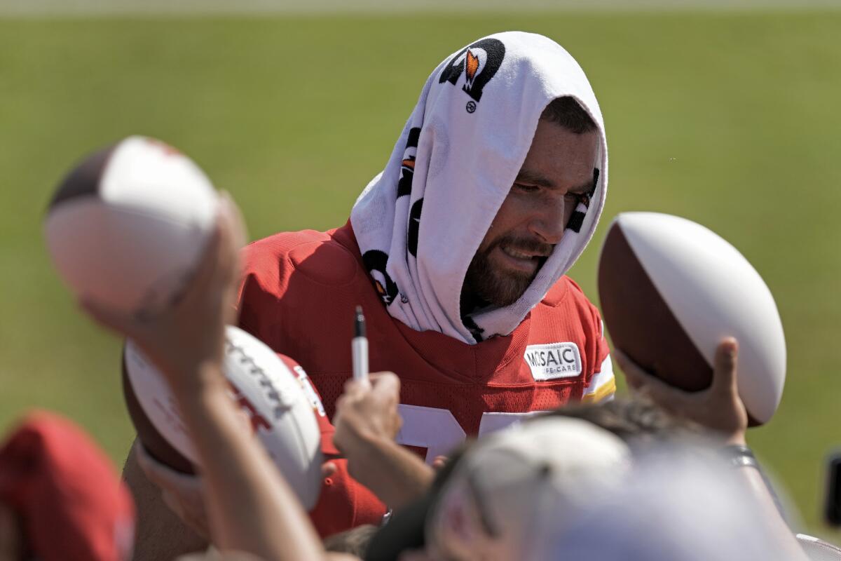 Kansas City Chiefs tight end Travis Kelce signs autographs during training camp.
