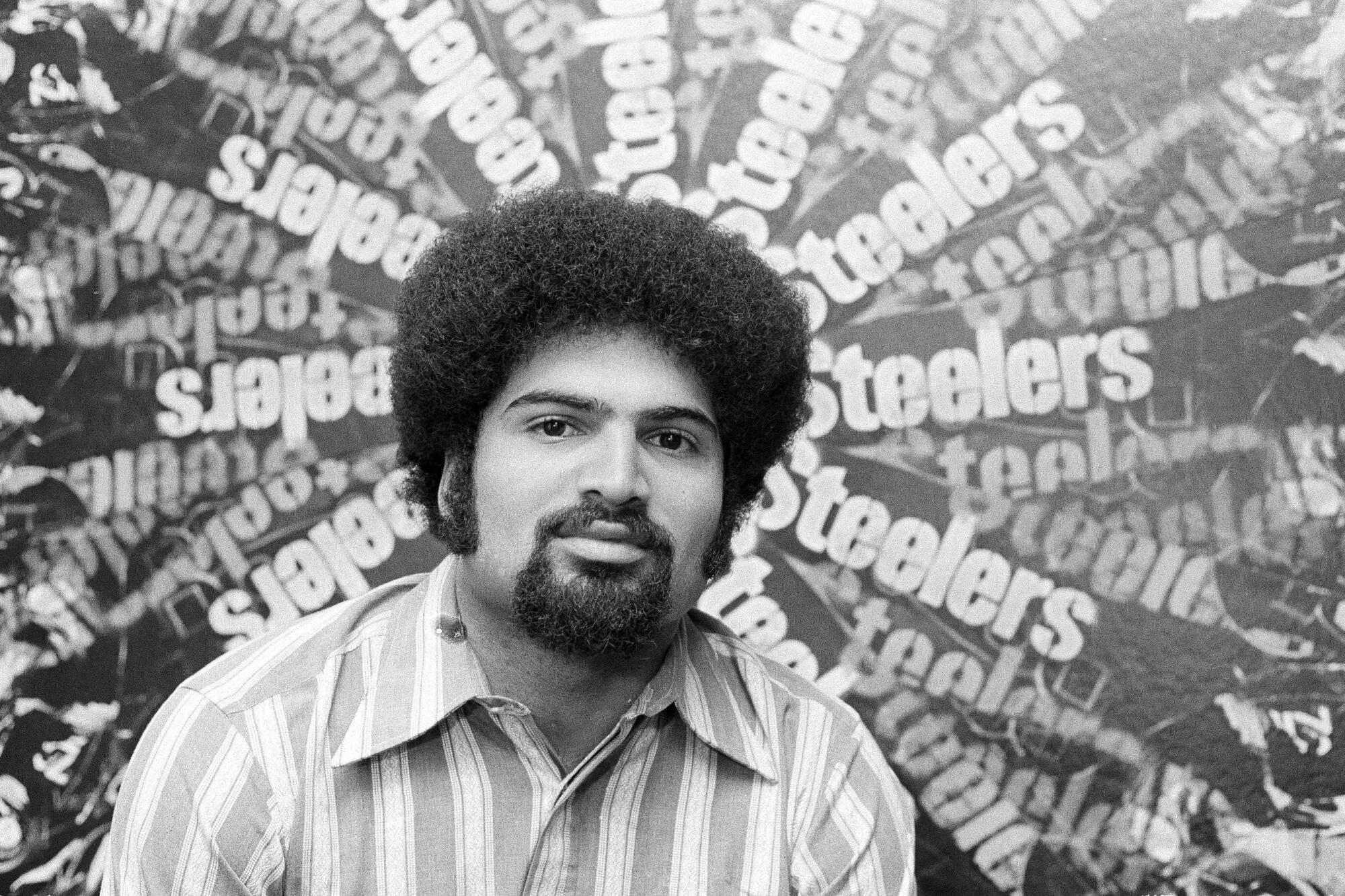 Franco Harris sits in front of a collage of Steelers posters in 1973.
