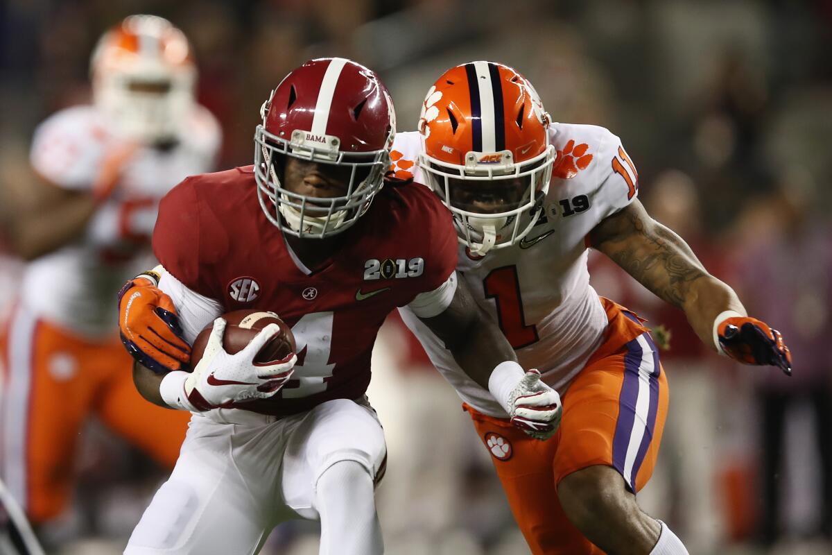 Alabama's Jerry Jeudy is pursued by Clemson's Isaiah Simmons.