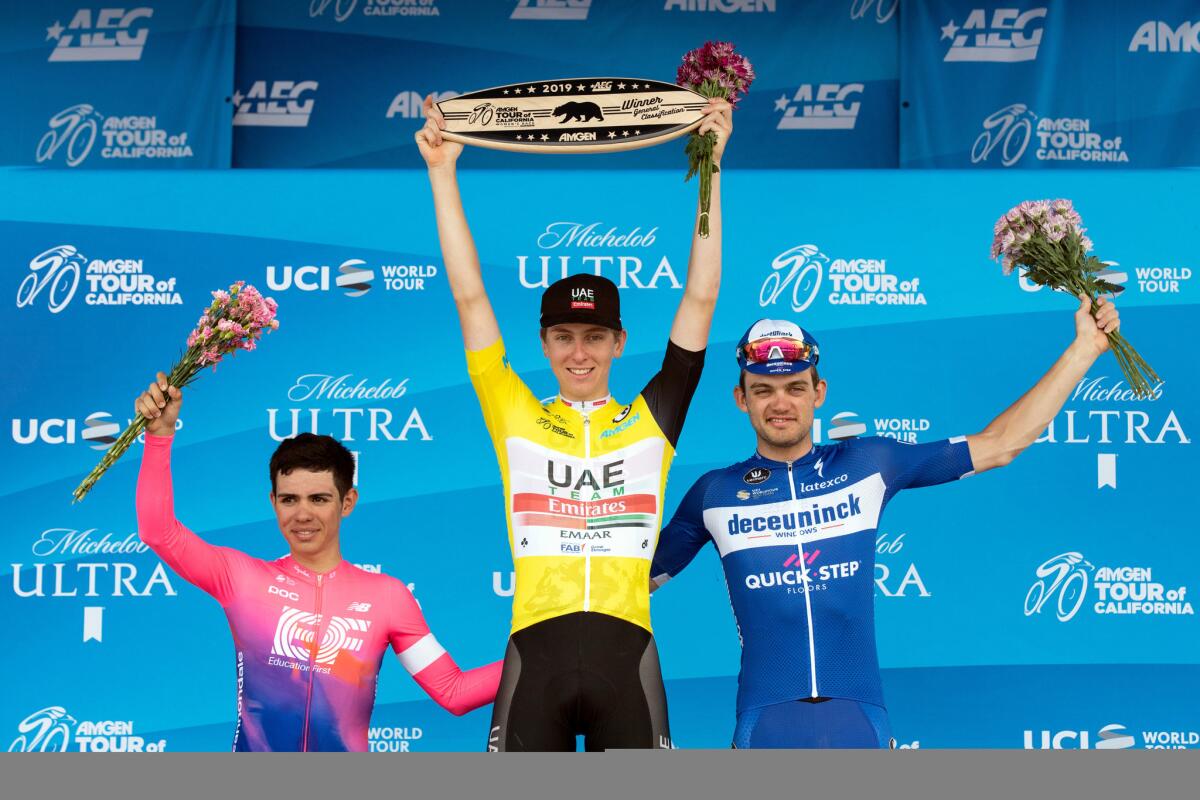 Tour of California winner Tadej Pogacar, celebrates on the podium with runner-up Sergio Higuita, right, and third-placer Kasper Asgreen.