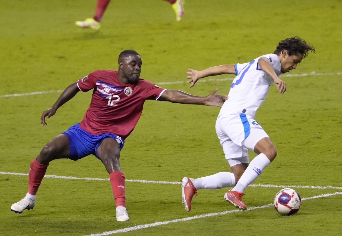 El Salvador's Enrico Duenas, right, and Costa Rica's Joel Campbell battle for the ball during a qualifying soccer match for the FIFA World Cup Qatar 2022 at National stadium in San Jose, Costa Rica, Sunday, Oct. 10, 2021. (AP Photo/Moises Castillo)