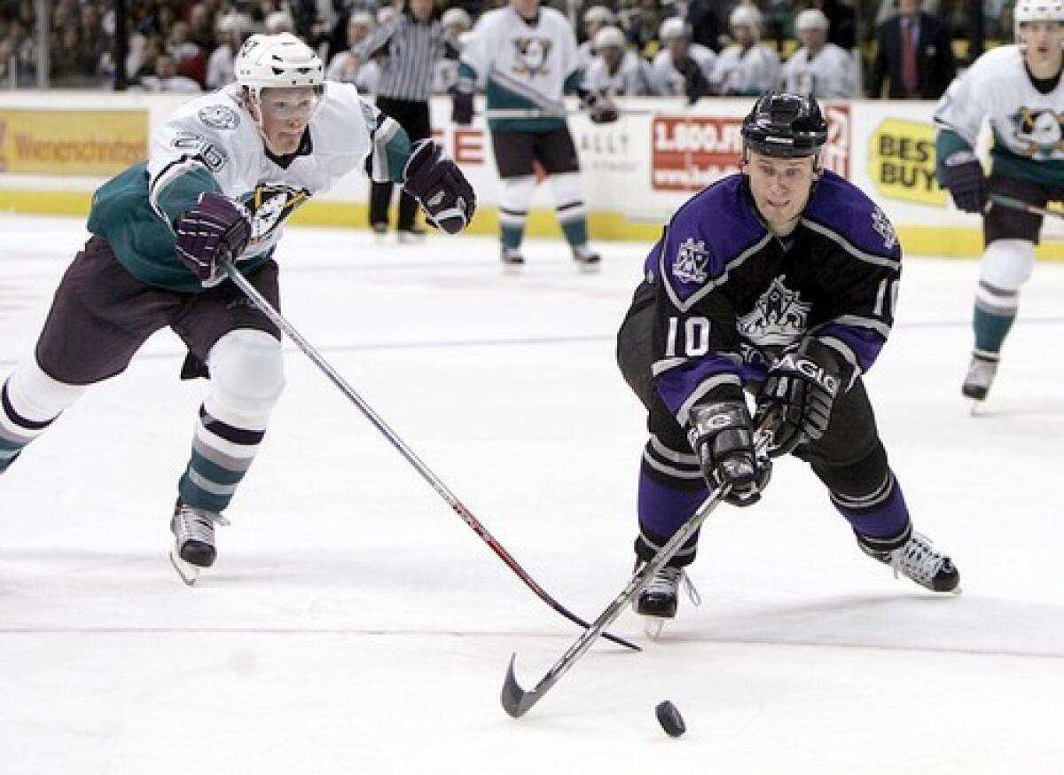 Kings' Nathan Dempsey battles Mighty Ducks' Samuel Pahlsson for the puck.