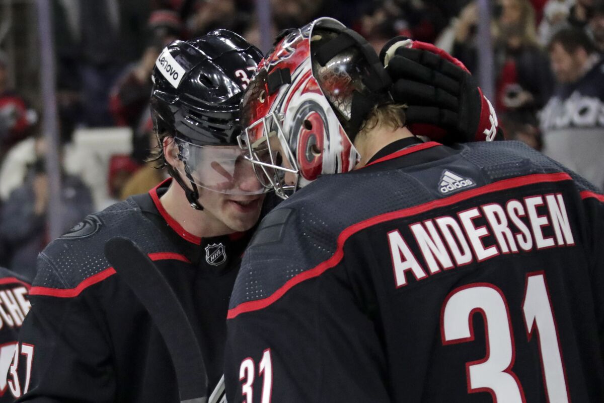 Carolina Hurricanes right wing Andrei Svechnikov, left, congratulates goaltender Frederik Andersen (31) on a win over the Calgary Flames at the end of an NHL hockey game Friday, Jan. 7, 2022, in Raleigh, N.C. (AP Photo/Chris Seward)