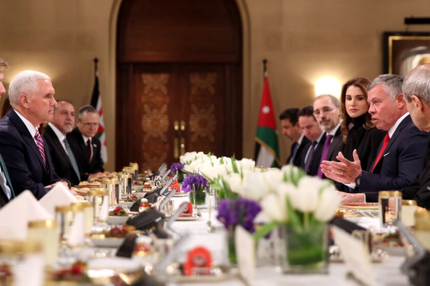 Jordan's King Abdullah II, right, speaks across a table to U.S. Vice President Mike Pence during a lunch at the royal palace in Amman.