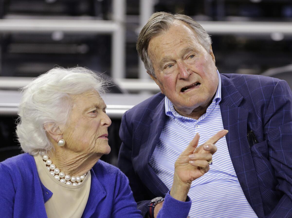 Former President George H.W. Bush and wife Barbara speak at a college basketball game in Houston on March 29, 2015.