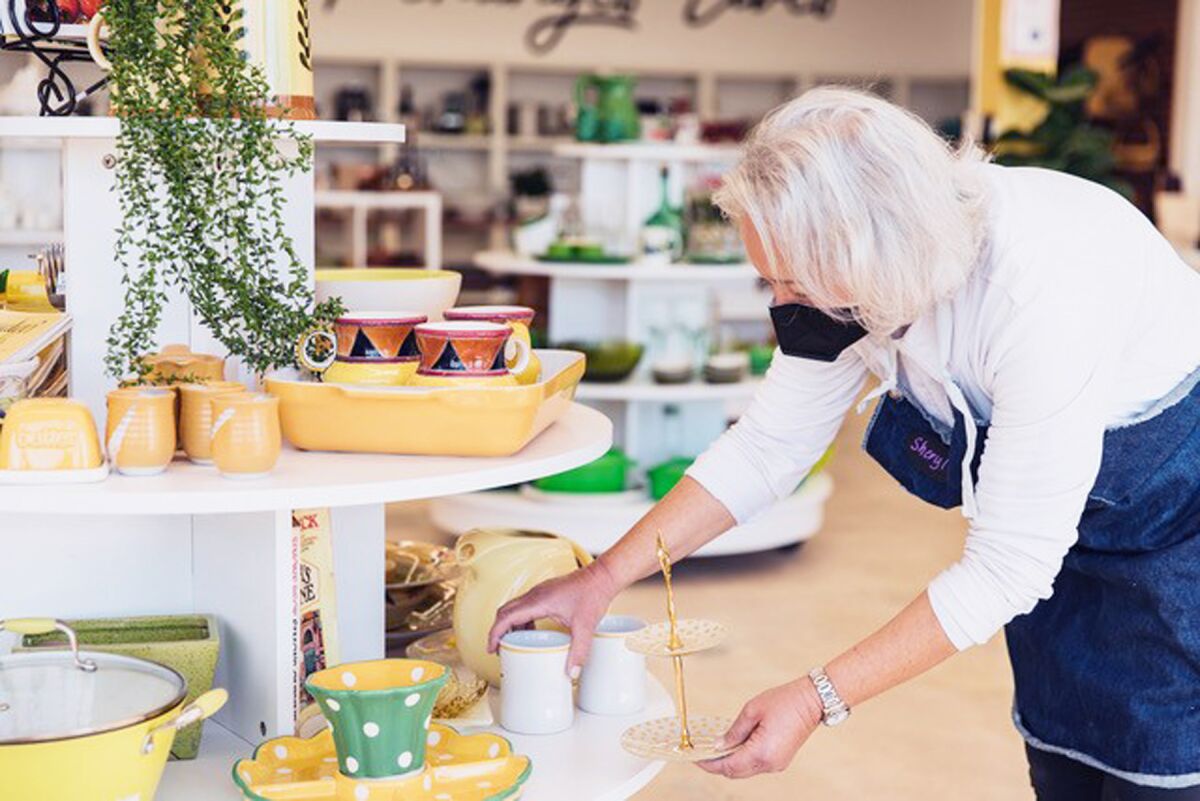 An employee placing items on display at the new Kitchens for Good Shop in Pacific Beach.