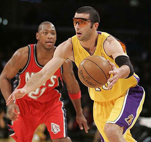 Lakers forward Vladimir Radmanovic, wearing protective glasses, drives to the basket against Bobby Simmons of the New Jersey Nets in the first quarter Tuesday night.
