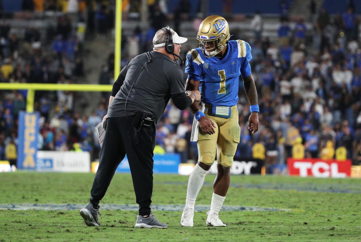 UCLA coach Chip Kelly speaks with quarterback Dorian Thompson-Robinson before a touchdown play.