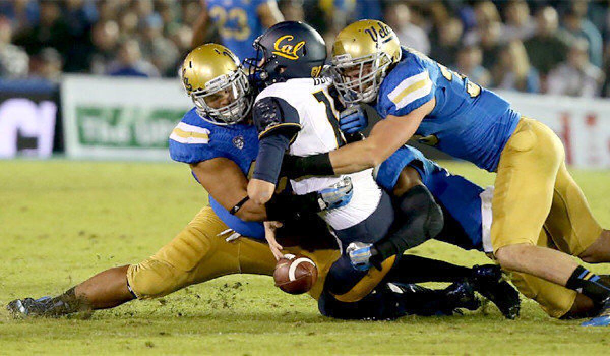 UCLA defensive end Eddie Vanderdoes, left and linebacker Jordan Zumwalt, right, sack California quarterback Jared Goff during the Bruins' 37-10 win over the Golden Bears at the Rose Bowl on Oct. 12.