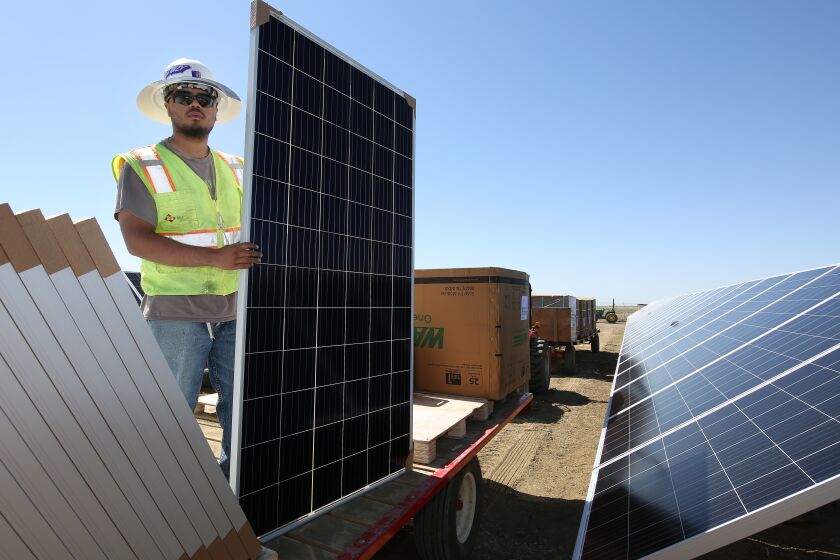 LEMOORE CA JUNE 24, 2021 - Ricky Figueroa places panels at the construction site of Westlands Solar Park, which when completed will be one of the largest solar farms in the nation located in Lemoore, Calif., Thursday, June 24, 2021.(Gary Kazanjian/For The Times)