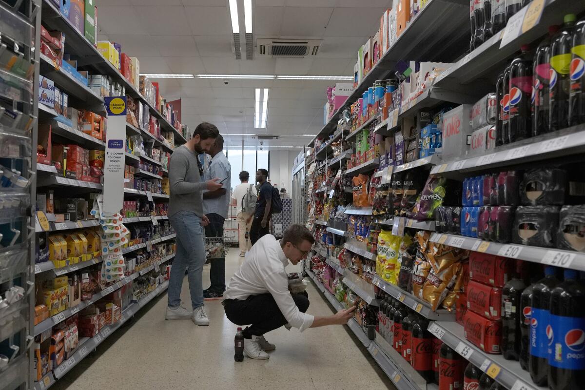 FILE - Shoppers buy food in a supermarket in London, Wednesday, Aug. 17, 2022. Britain’s new Prime Minister Liz Truss has pledged to rebuild the economy, but she faces a daunting job. Truss inherits an ailing economy on the brink of a potentially long recession, with record inflation and millions crying out for government help to cope with energy bills. (AP Photo/Frank Augstein, File)