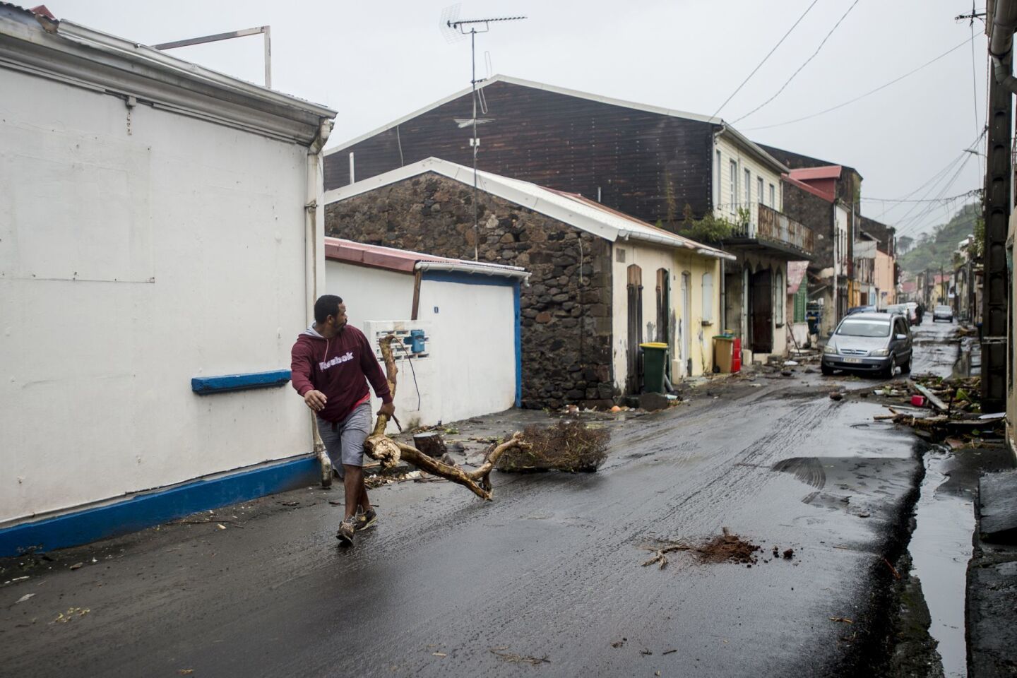 A man clears debris from a street in Saint-Pierre, on the French Caribbean island of Martinique, after it was hit by Hurricane Maria.