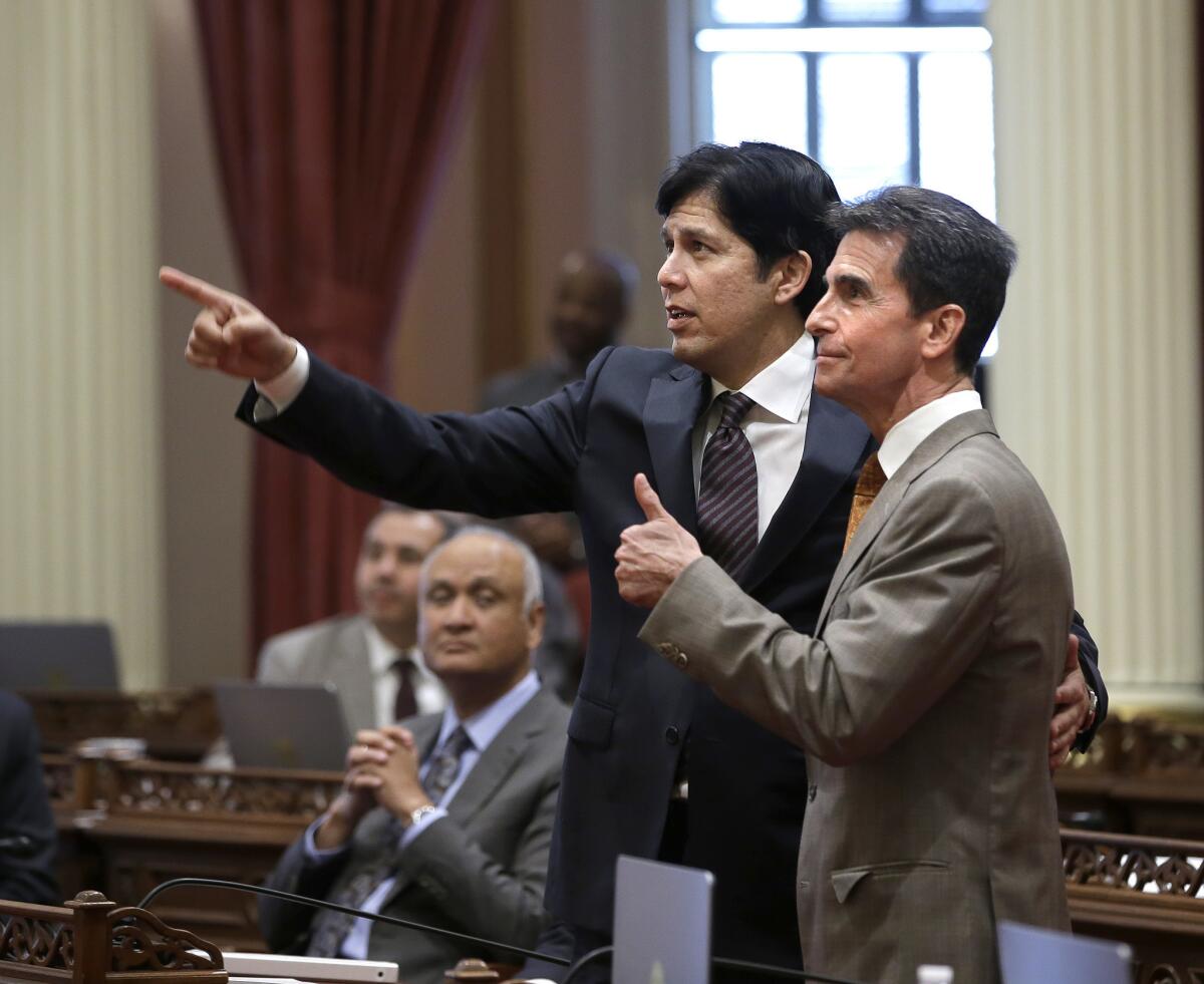 State Sen. Mark Leno, right, and Senate President Pro Tem Kevin de León watch as votes on the minimum wage bill are posted in the Capitol on March 31. The bill, which would raise the wage to $15 an hour by 2022, was approved by both houses of the Legislature.