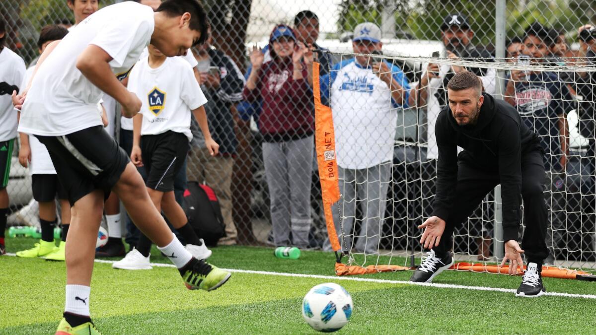 David Beckham participates in soccer drills with youth at a refurbished community soccer field at The Salvation Army Red Shield Youth & Community Center on Friday in Los Angeles.