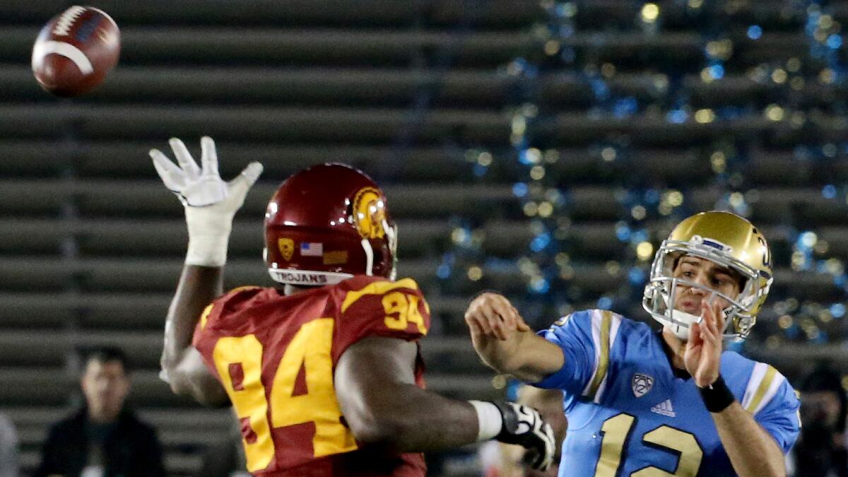UCLA quarterback Mike Fafaul gets a pass off while under pressure from USC defensive tackle Rasheem Green in the fourth quarter Saturday night.