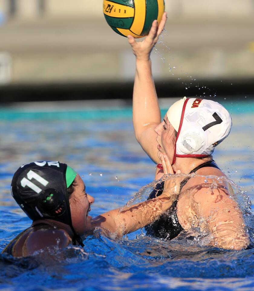 Estancia High's Alexis Discenzo (7) passes the ball defended by Costa Mesa's Melissa Folkerts (11) during the first half in an Orange Coast League game on Wednesday.