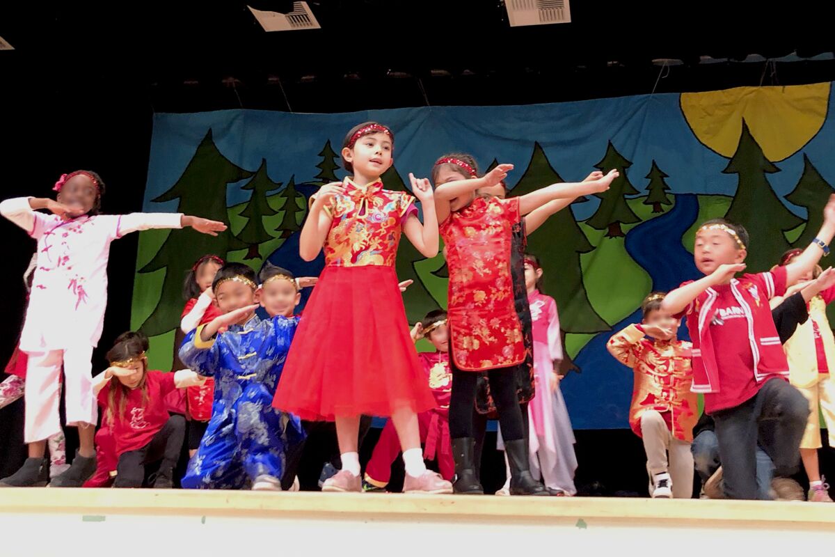 First-grader Natalie M. (center) performs with her classmates during Barnard Mandarin Magnet Elementary School’s Chinese New Year celebration held earlier in the year, before all area schools closed due to coronavirus concerns.