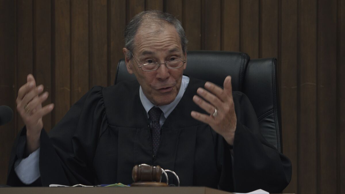 "Judge Alan" gestures from behind the bench in "Jury Duty"