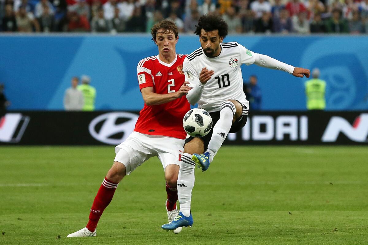 Mohamed Salah of Egypt controls the ball unde rpressure of Mario Fernandes of Russia during the 2018 FIFA World Cup Russia group A match between Russia and Egypt at Saint Petersburg Stadium on June 19, 2018 in Saint Petersburg, Russia.