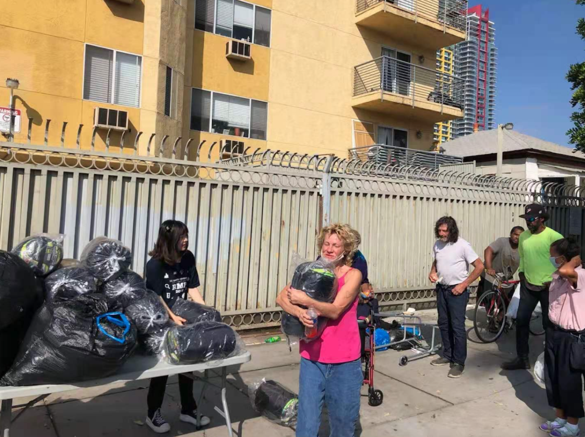 Setting up sleeping bag and care package distribution: a table to support resources and an IAY member behind the table.