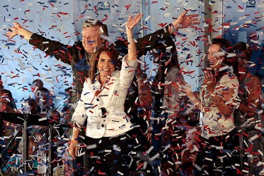 Rep. Michele Bachmann, with her husband, Marcus, waves to the crowd after placing first in the Ames straw poll.