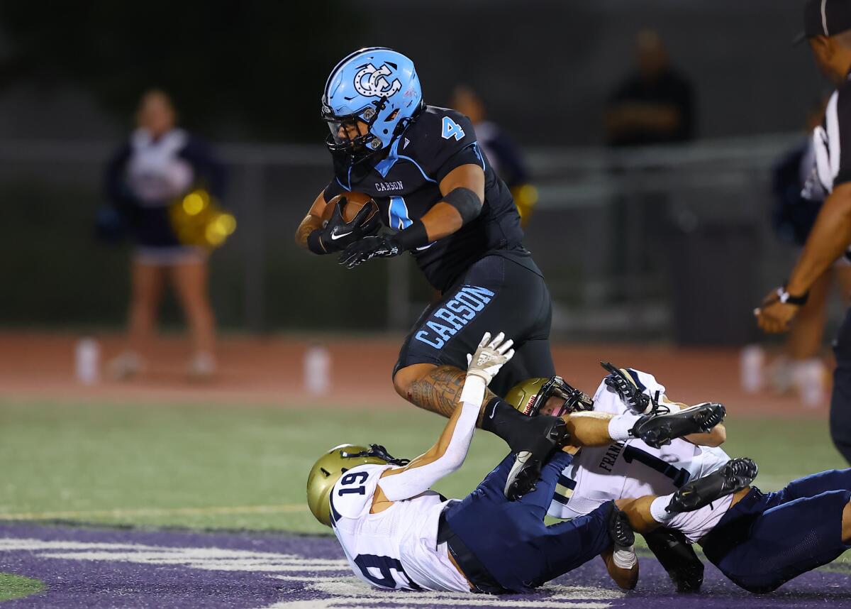 Carson's Jerry Misaalefua jumps over Franklin defenders.