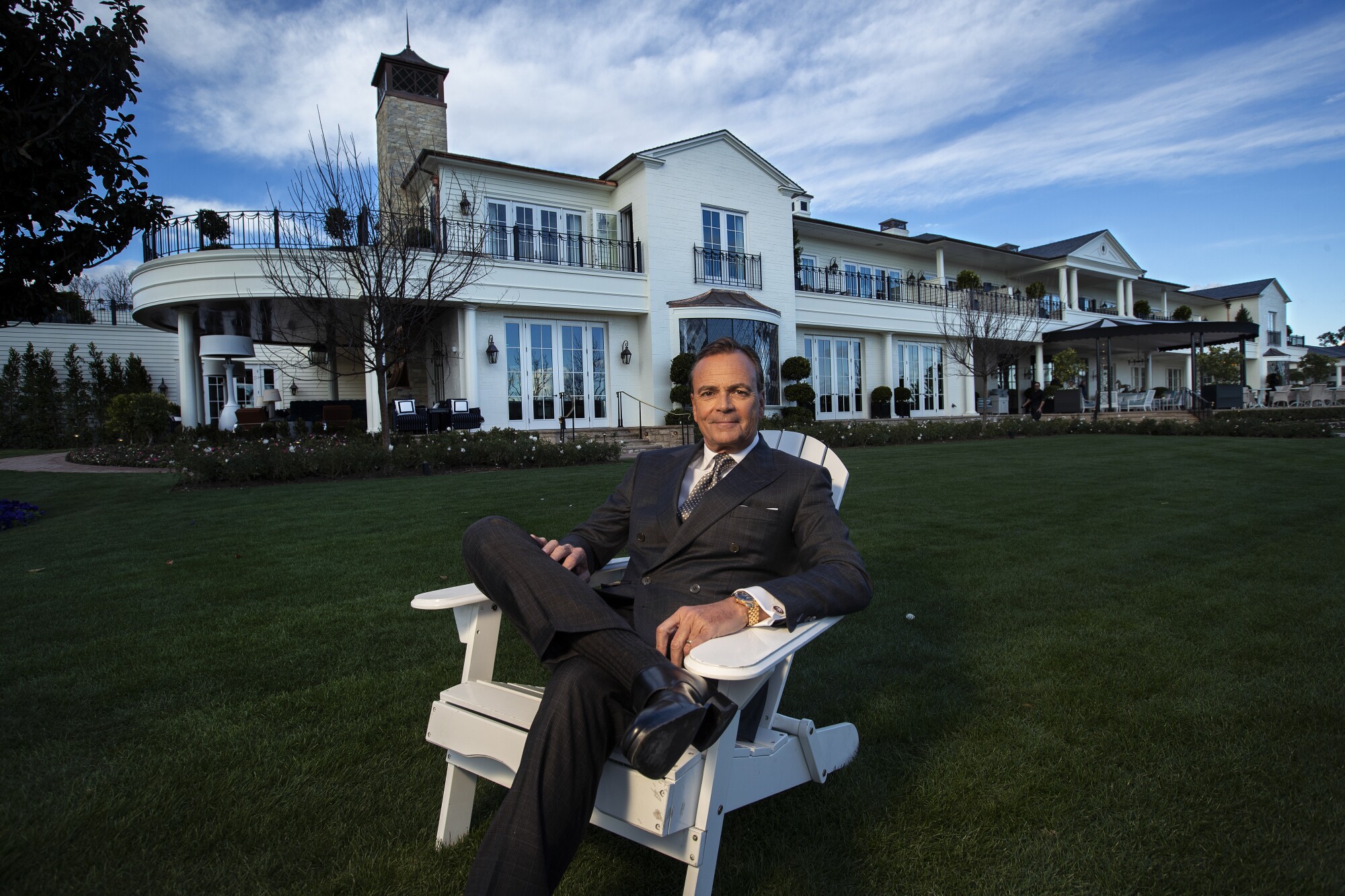 Rick Caruso in a chair in front of a mansion