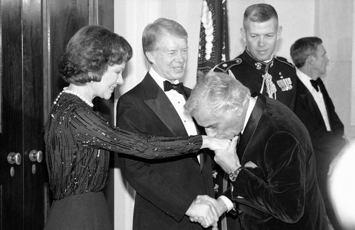 Leonard Bernstein kisses the hand of Rosalynn Carter.
