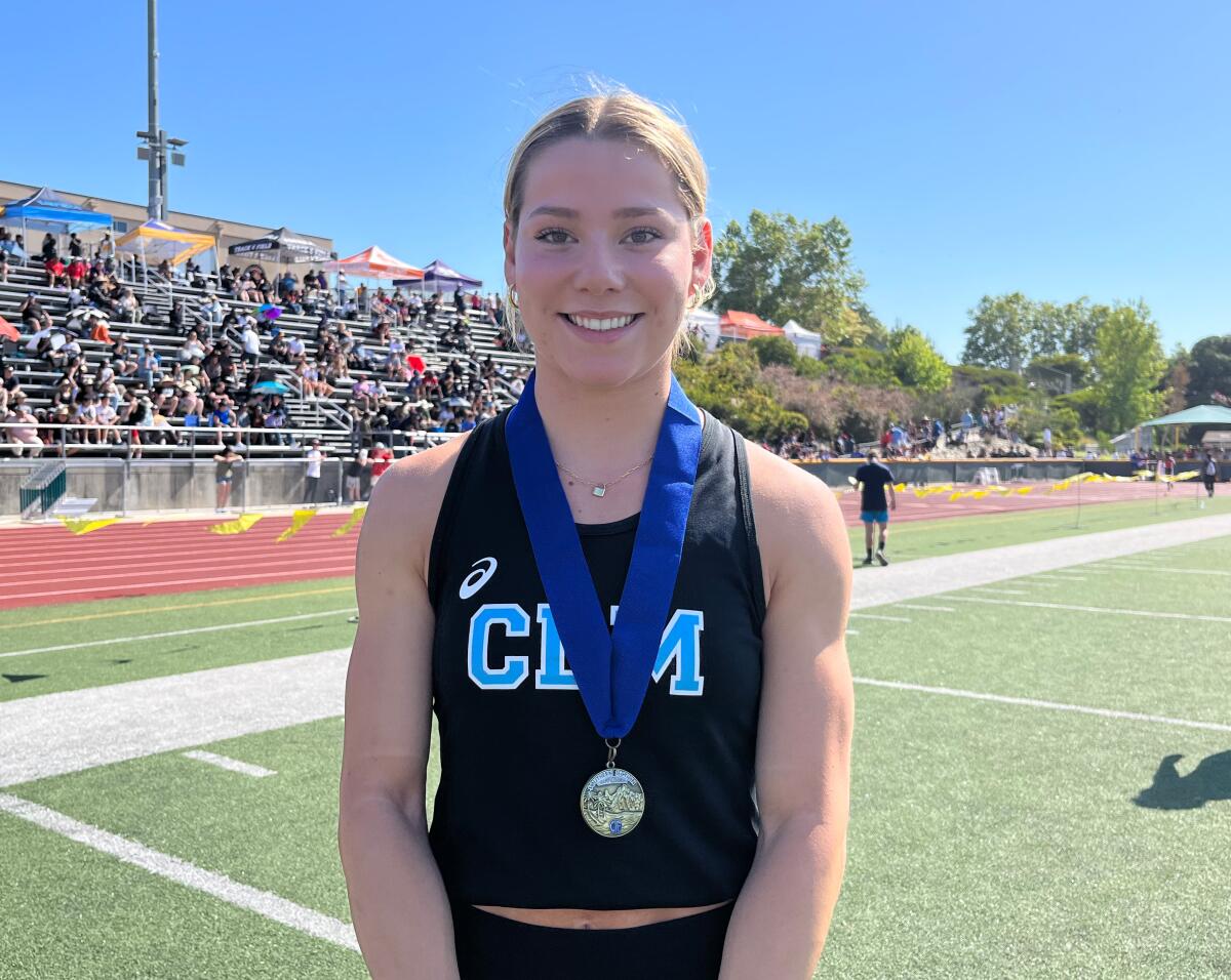 Corona del Mar junior Ava Simos with her first-place medal after winning the Division 3 girls' 100-meter race.