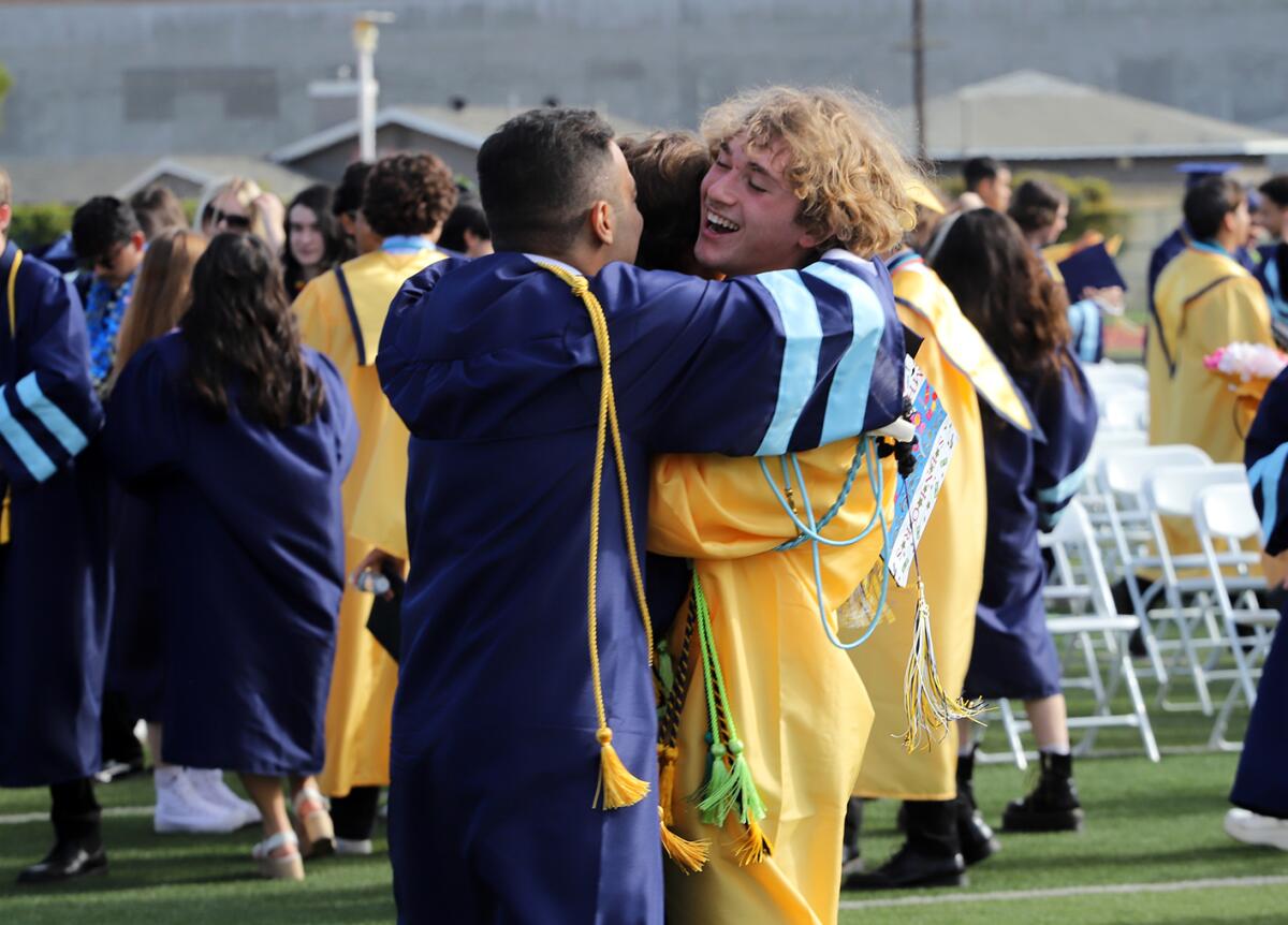 Marina High School graduates hug one another after collecting their diplomas.