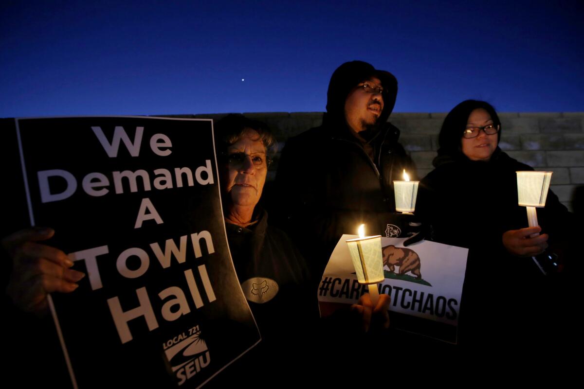 From left, Doryce Caballero, 59, Dwyn Valdriz, 35, and Carole Lynn Valdriz, 35, take part in a candlelight vigil in Lancaster.