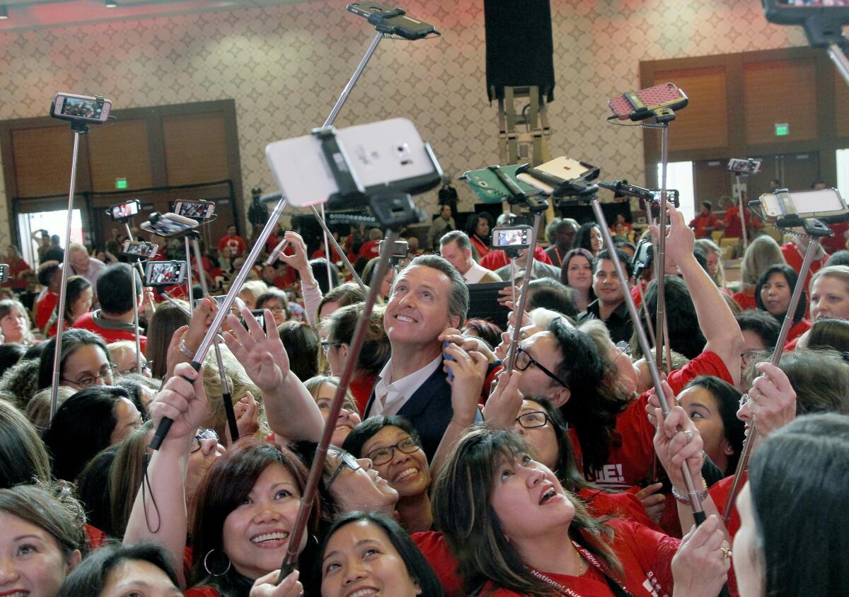 Gavin Newsom, California's lieutenant governor, has his photo taken with registered nurses from California and across the nation in Los Angeles, Wednesday, Dec. 2, 2015. The politically powerful California Nurses Association announced Wednesday that it is endorsing Newsom's bid to become governor nearly three full years before the general election contest. (AP Photo/Nick Ut)