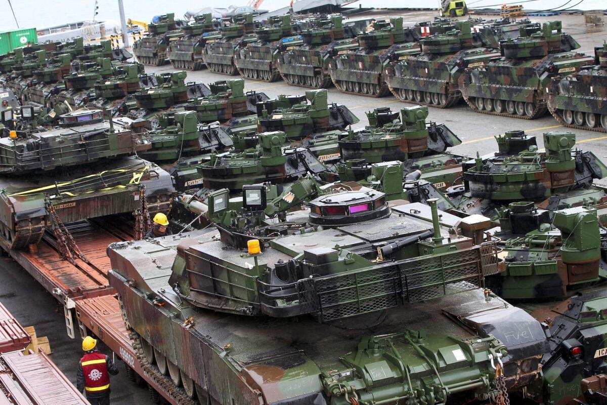 U.S. Abrams tanks and Bradley fighting vehicles of the 12th Army Cavalry regiment are unloaded at Busan, South Korea.